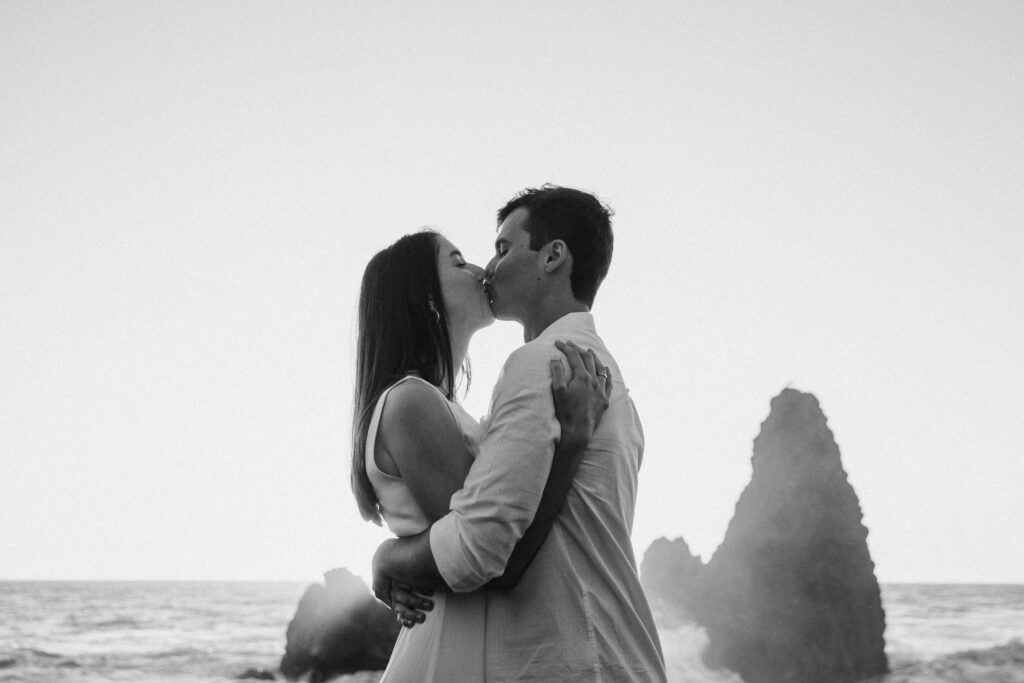 Couple sharing a kiss at Rodeo Beach in San Francisco.