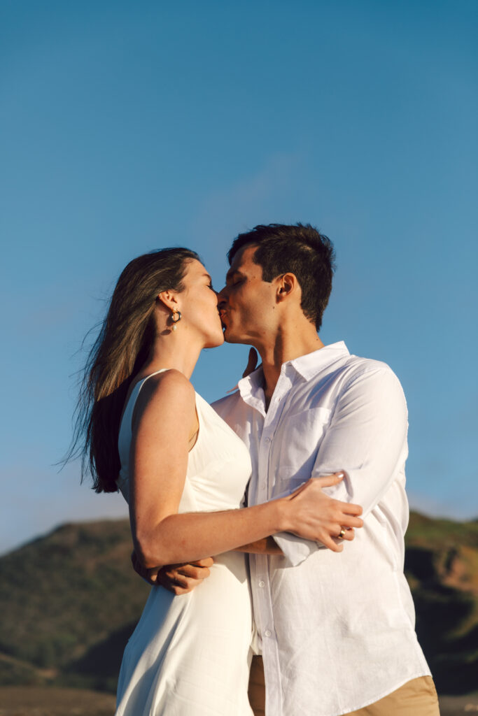 couple sharing a kiss on Rodeo Beach in San Francisco. 