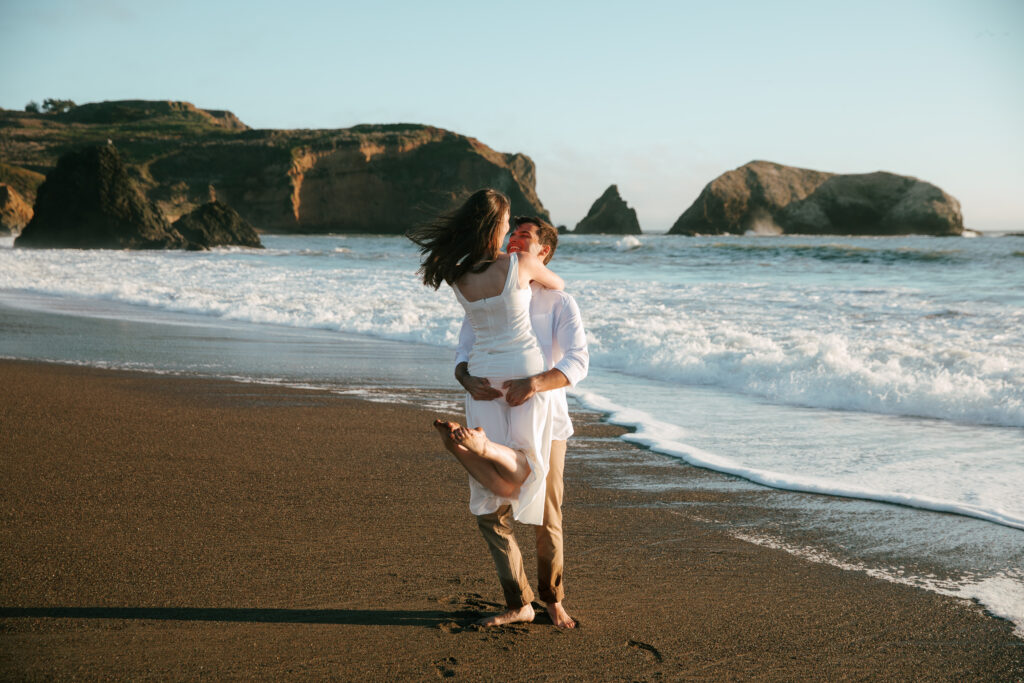 man twirling woman at Rodeo beach