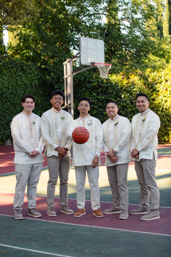 Groomsmen with groom on the basketball court.