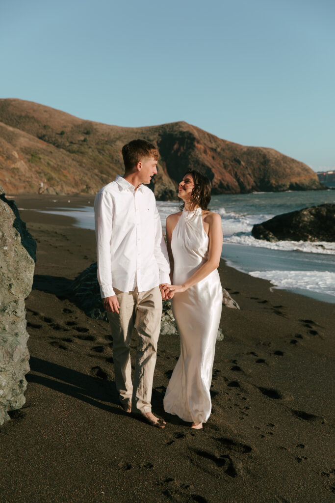 engaged couple walking together on the beach in California