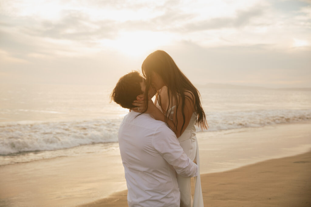 Couple sharing a kiss on the beach during their engagement photo session in Point Reyes California. 
