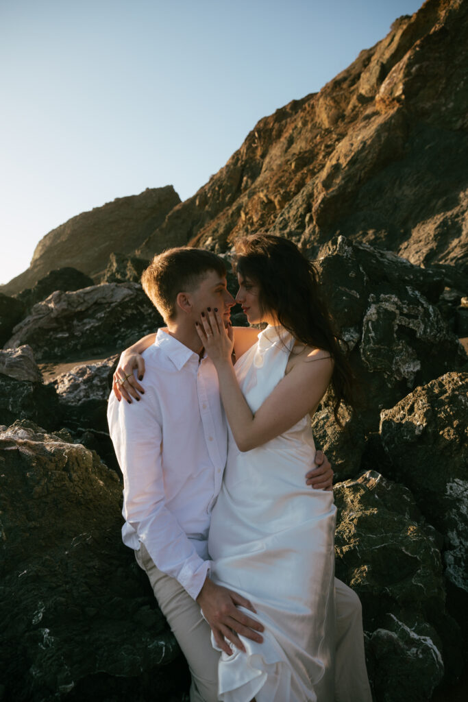 Couple looking at each other for their engagement photos at black sands beach