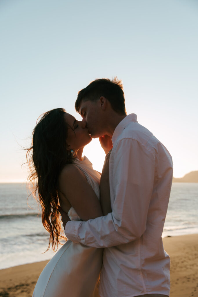 engaged couple sharing a kiss on the beach in California