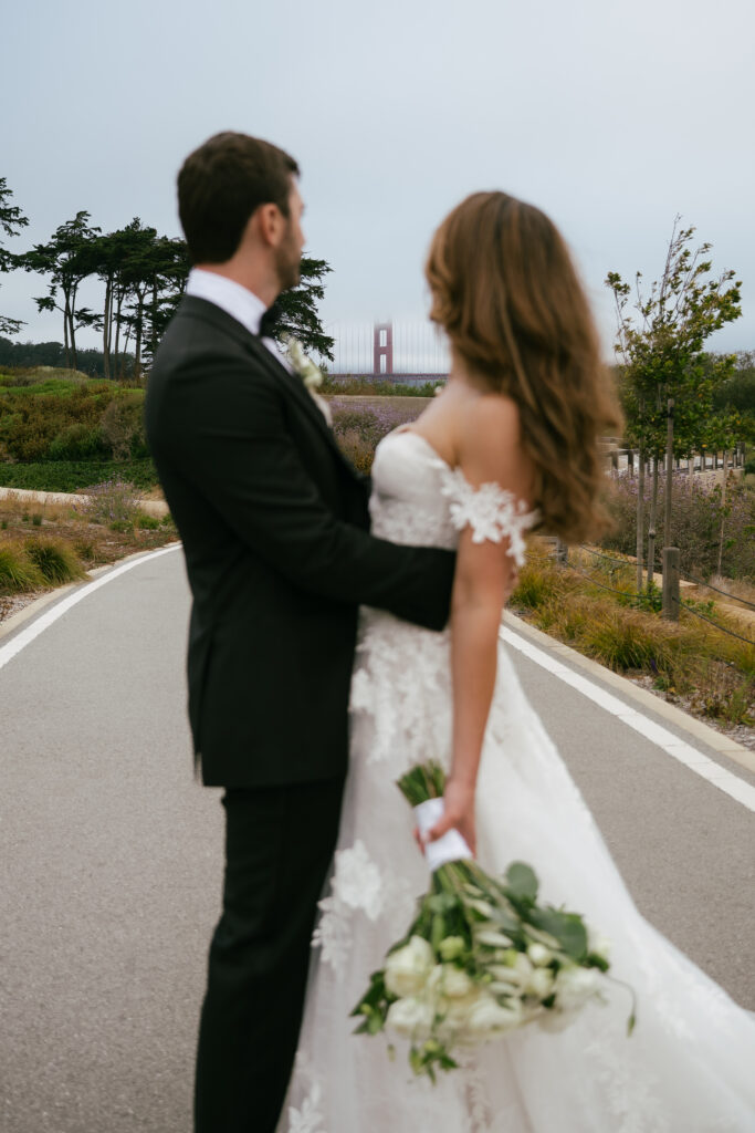 Bride and groom looking at the Golden Gate Bridge. 