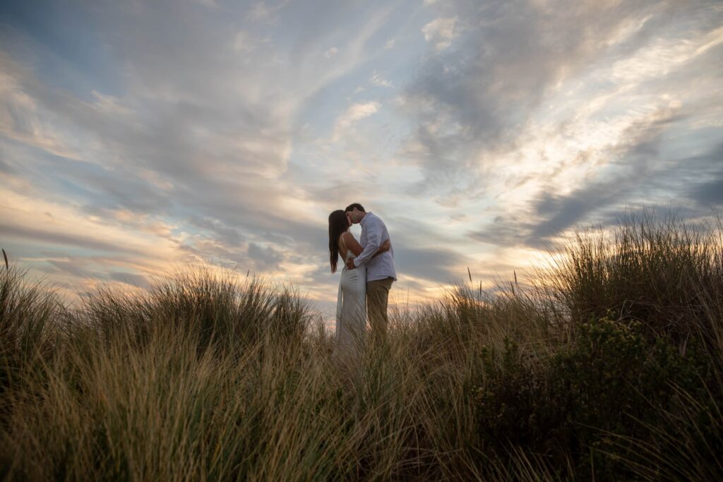 Couple kissing in the dunes at Point Reyes at sunset, Bay Area engagement photographer Rose Freedman