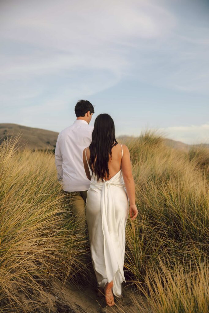 Couple walking through Point Reyes grasslands, Bay Area engagement photographer