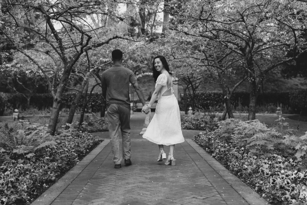 Couple walking hand in hand through Shakespeare Garden Golden Gate Park, Bay Area engagement photographer Rose Freedman
