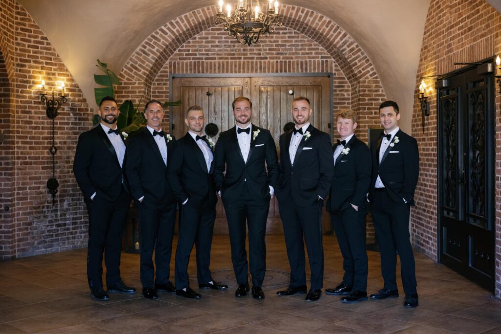 Groomsmen in black tuxedos inside cave entrance at Meritage Resort and Spa Napa wedding