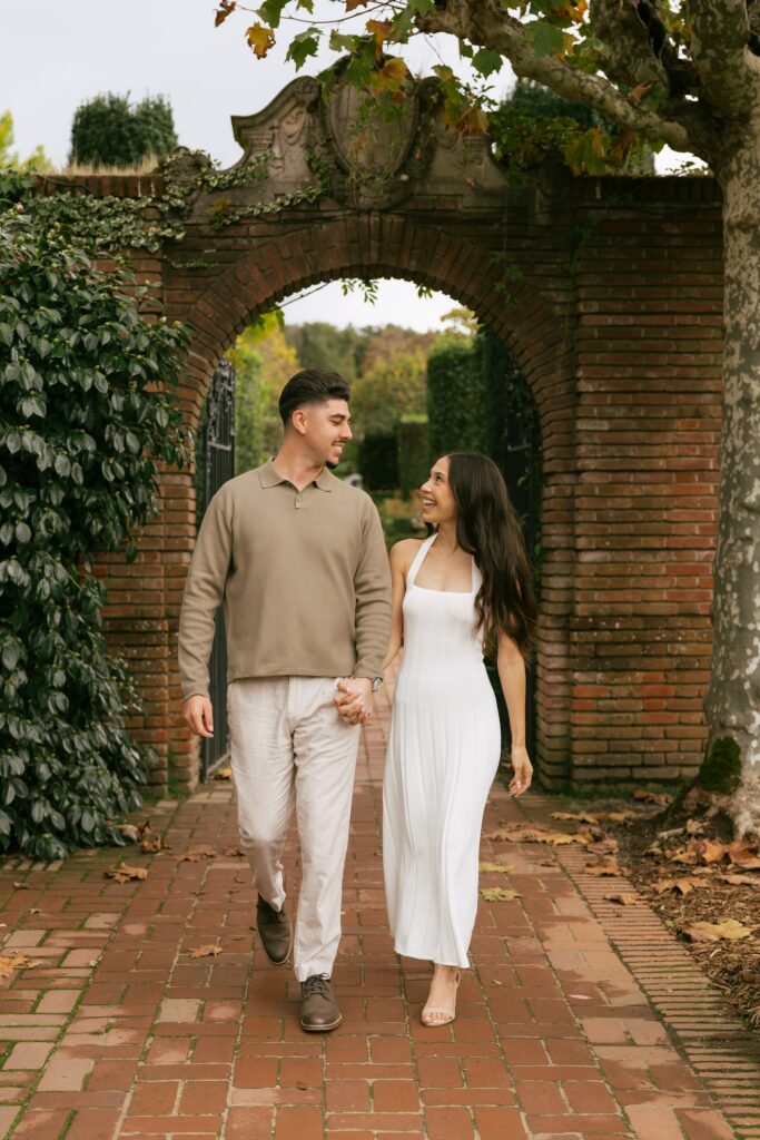Couple walking hand in hand through ivy-covered gate at Filoli Estate, Bay Area engagement photographer Rose Freedman