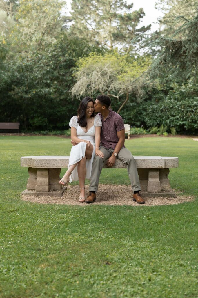 Couple sitting on stone bench at Shakespeare Garden Golden Gate Park, Bay Area engagement photographer