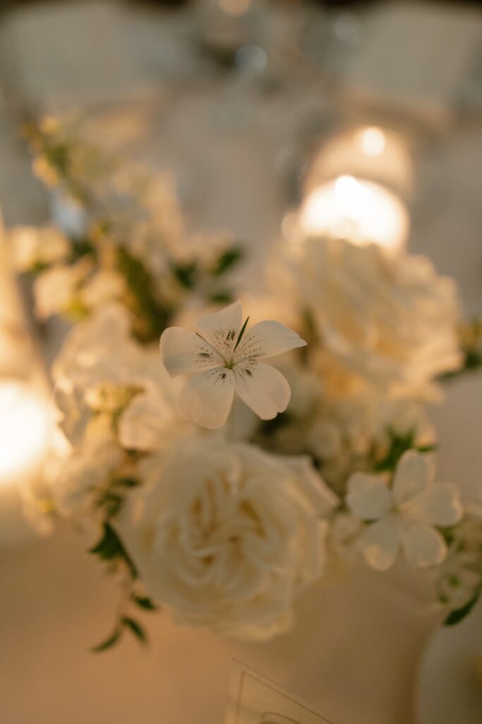 White garden rose and lily floral centerpiece with candlelight at Meritage Resort Napa cave reception