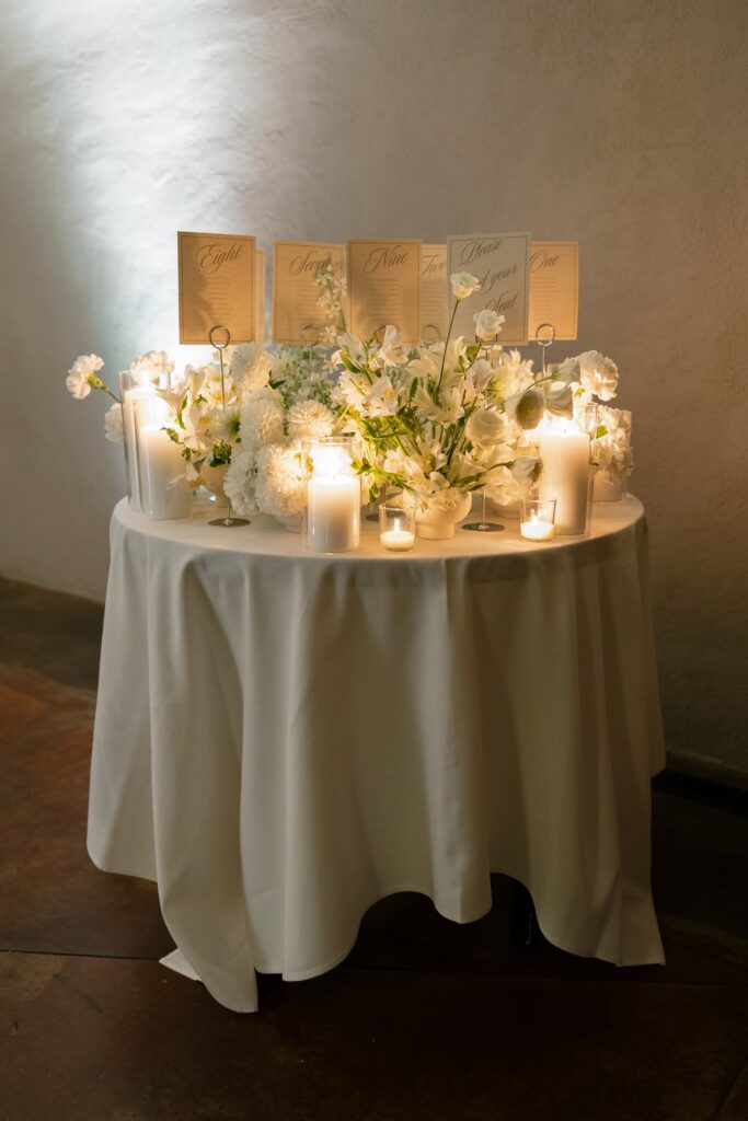 Wedding escort card table with white florals and candles at Meritage Resort Napa Valley black tie wedding
