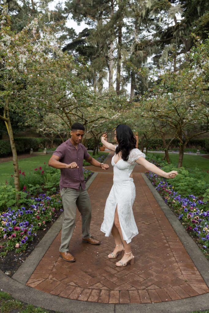 Couple dancing along garden path at Shakespeare Garden Golden Gate Park, San Francisco engagement photographer Rose Freedman