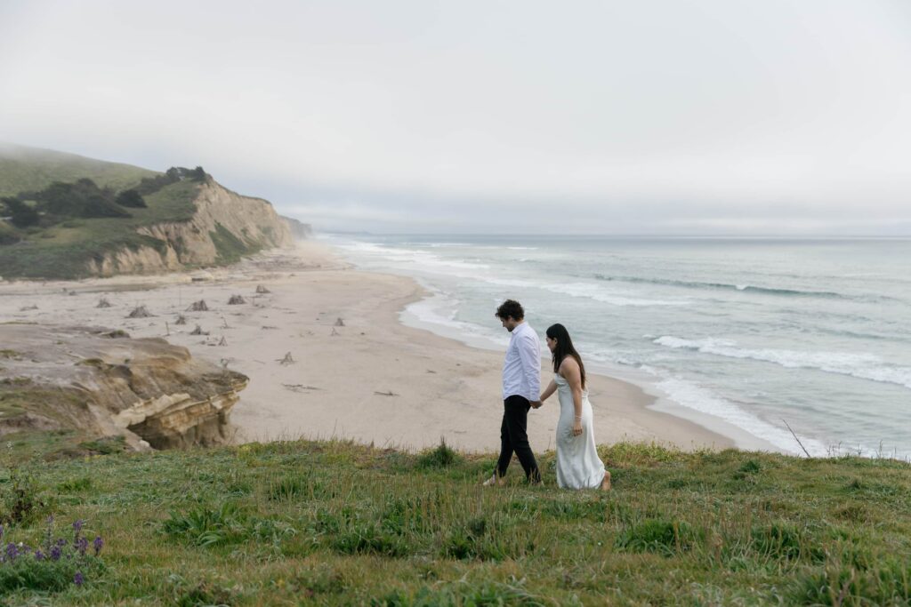 Couple walking along Half Moon Bay bluffs, Bay Area engagement session