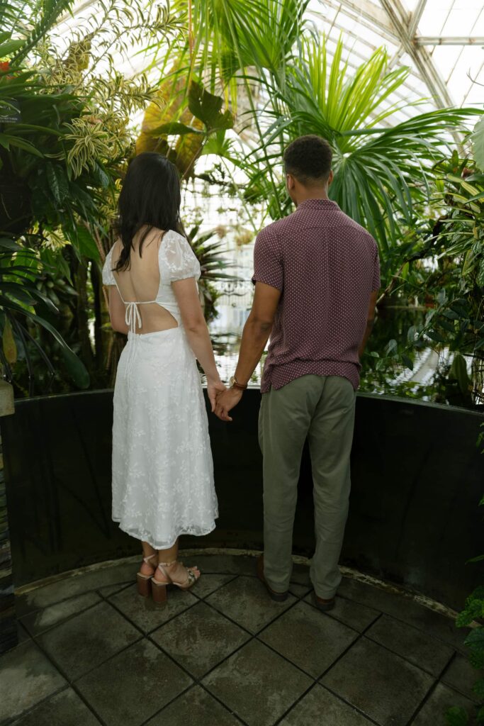 Couple holding hands inside Conservatory of Flowers Golden Gate Park, San Francisco engagement photographer Rose Freedman