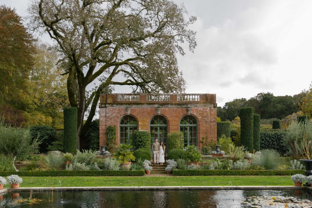 Couple standing at Filoli Estate garden pavilion with reflecting pool, Bay Area engagement photographer Rose Freedman