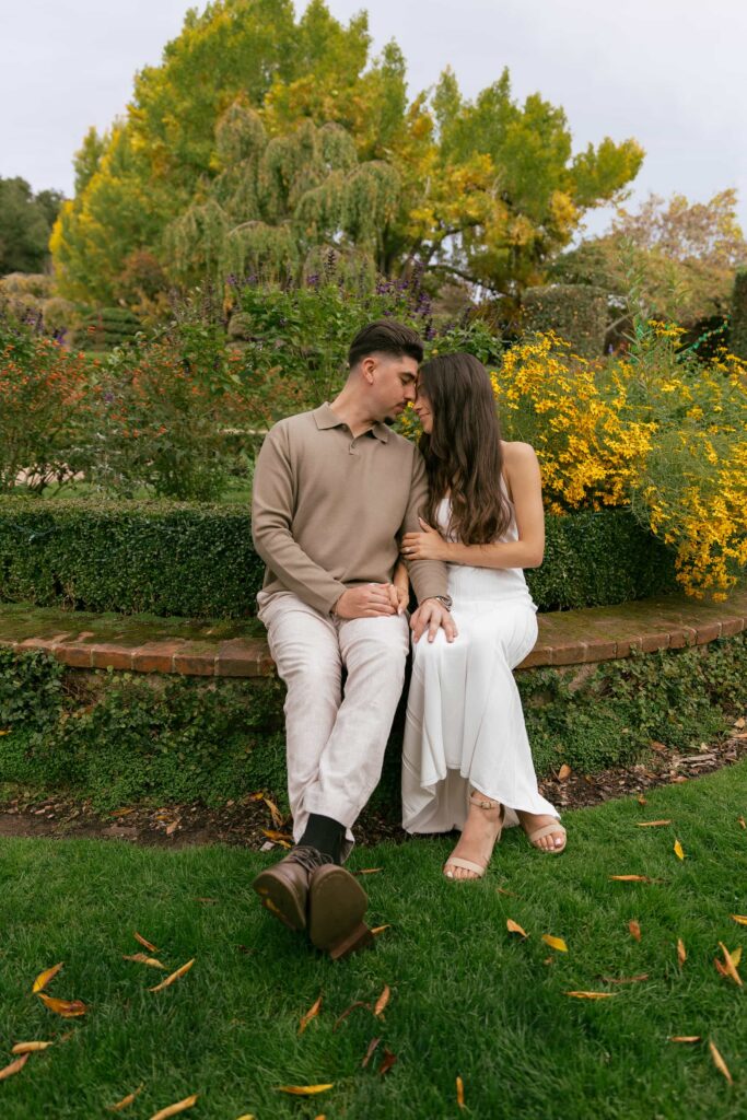 Couple sitting together in autumn garden at Filoli Estate Woodside, San Francisco Peninsula engagement photographer

