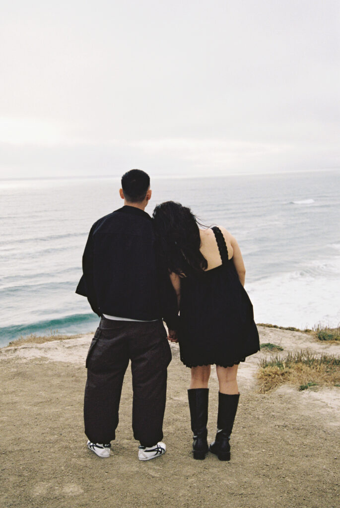 Couple looking out at ocean from Half Moon Bay coastal bluff on 35mm film, Bay Area photographer Rose Freedman