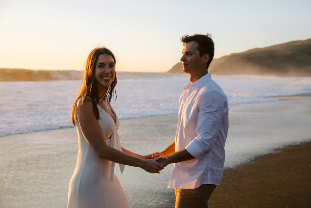 Couple dancing on Rodeo Beach at golden hour, Marin Headlands engagement photographer Rose Freedman