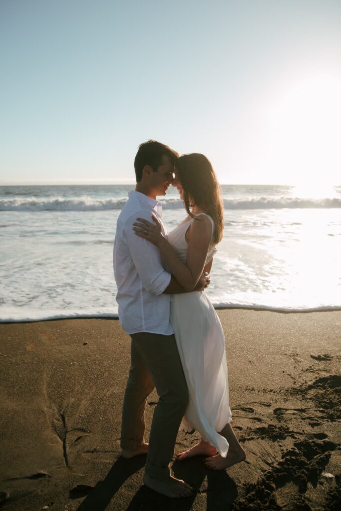 Couple on dark sand beach at Rodeo Beach Marin Headlands, San Francisco engagement photographer