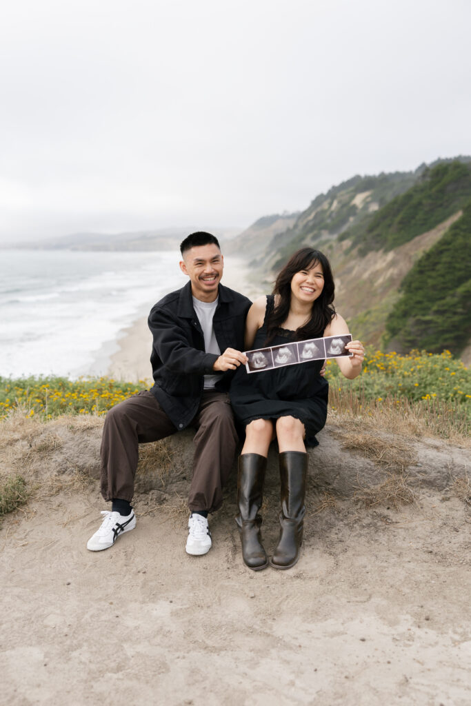Couple holding ultrasound pregnancy announcement at Half Moon Bay, Bay Area couples photographer Rose Freedman