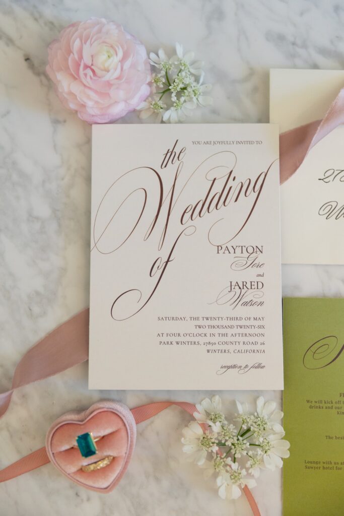 Wedding invitation with emerald ring in heart ring box and florals at Park Winters wedding, Rose Freedman Photography