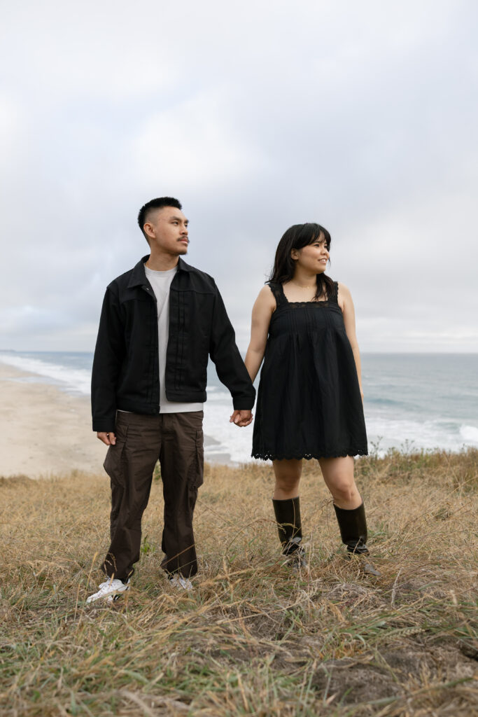 Couple holding hands on Half Moon Bay bluff, Bay Area couples photographer Rose Freedman