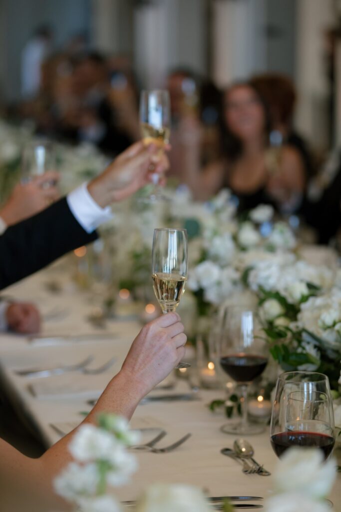 Wedding guests toasting with champagne at Flood Mansion reception dinner, San Francisco wedding photographer Rose Freedman