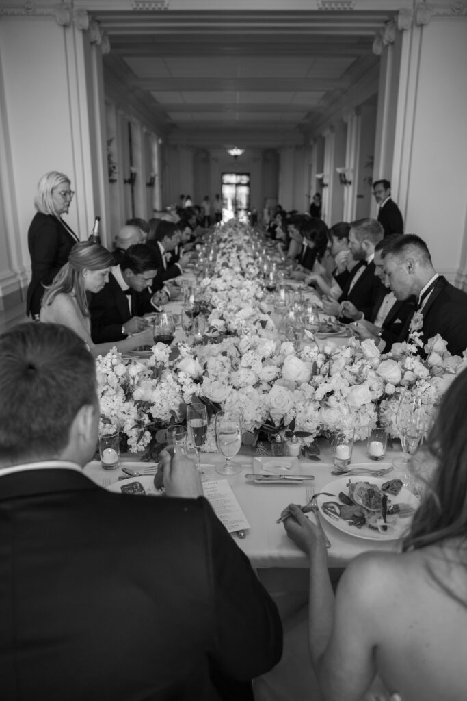 Guests seated at long feasting table during Flood Mansion wedding reception, San Francisco wedding photographer Rose Freedman