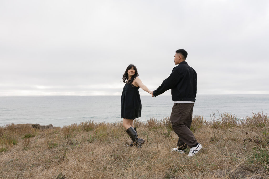 Couple walking on Half Moon Bay coastal bluff during couples session, Bay Area photographer Rose Freedman