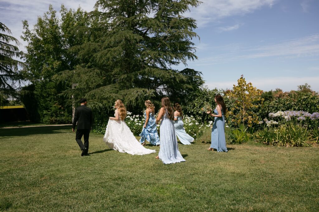 Bride walking with bridesmaids in blue dresses at Park Winters wedding, California wedding photographer Rose Freedman