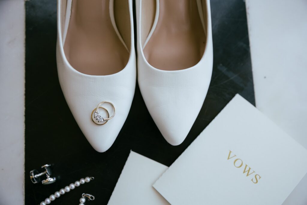 Bride's white heels, wedding rings, cufflinks, pearl necklace, and vow booklet at Kohl Mansion wedding, Rose Freedman Photography