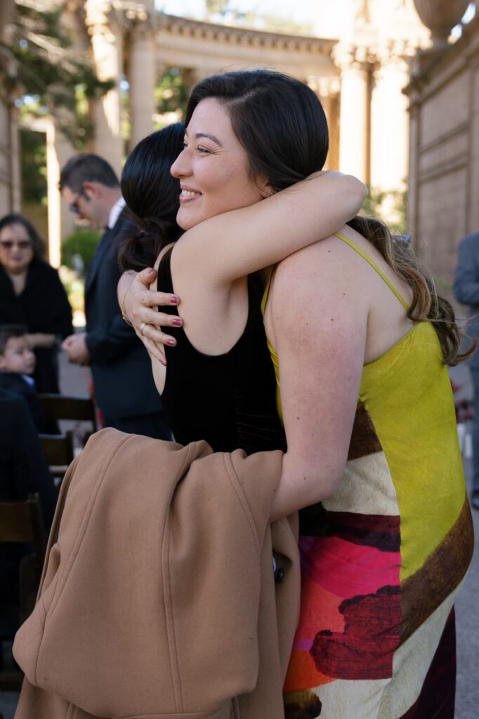 Wedding guests embracing after Palace of Fine Arts ceremony San Francisco, Rose Freedman Photography