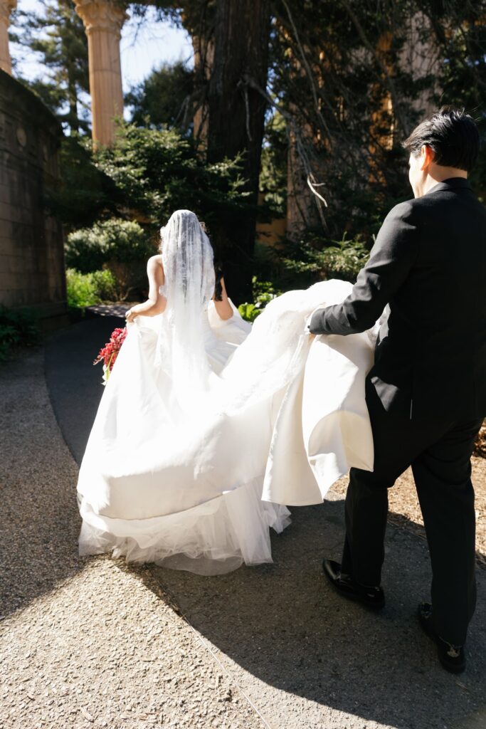 Bride and groom walking through Palace of Fine Arts columns, San Francisco wedding photographer Rose Freedman