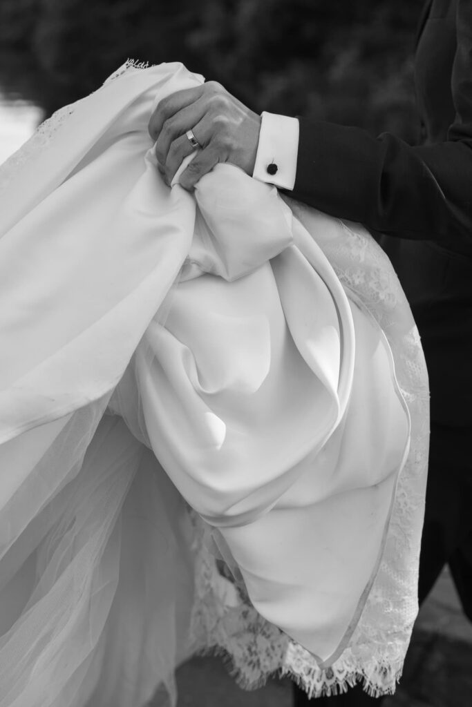 Bride and groom hands holding wedding dress detail at Palace of Fine Arts, San Francisco wedding photographer Rose Freedman