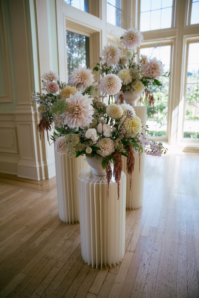 Blush and cream dahlia floral arrangement in white fluted vase at Kohl Mansion wedding, Bay Area wedding photographer Rose Freedman
