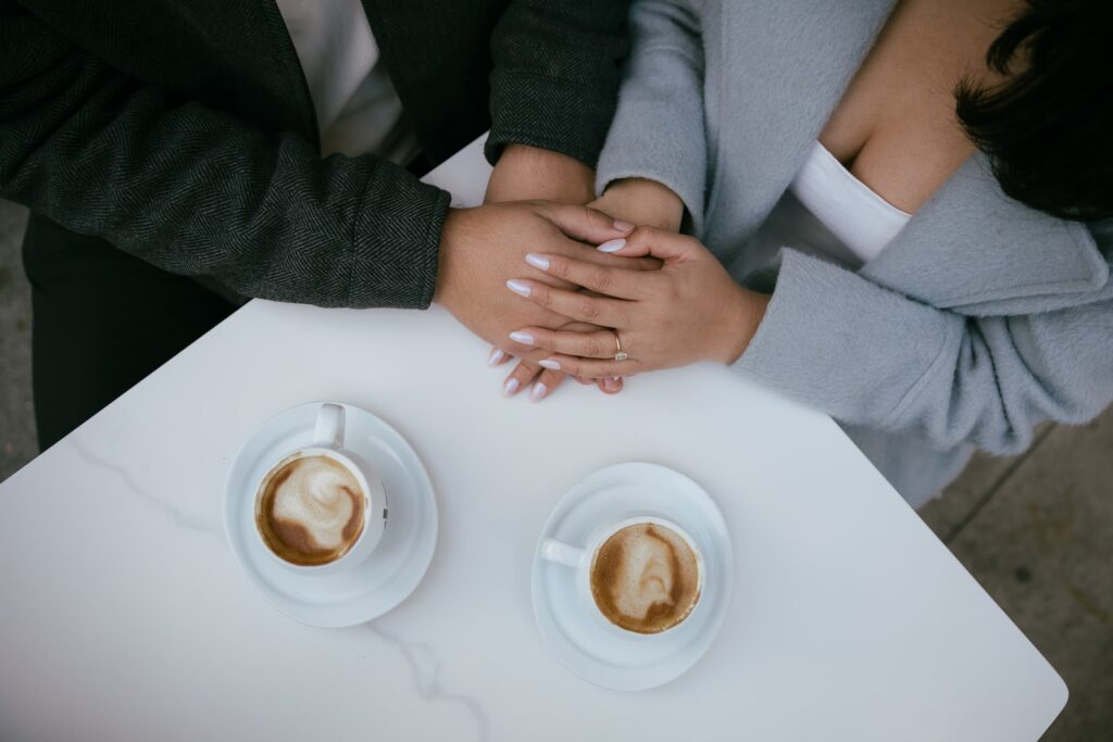 Engagement ring detail with coffee cups at San Francisco cafe, Bay Area engagement photographer Rose Freedman