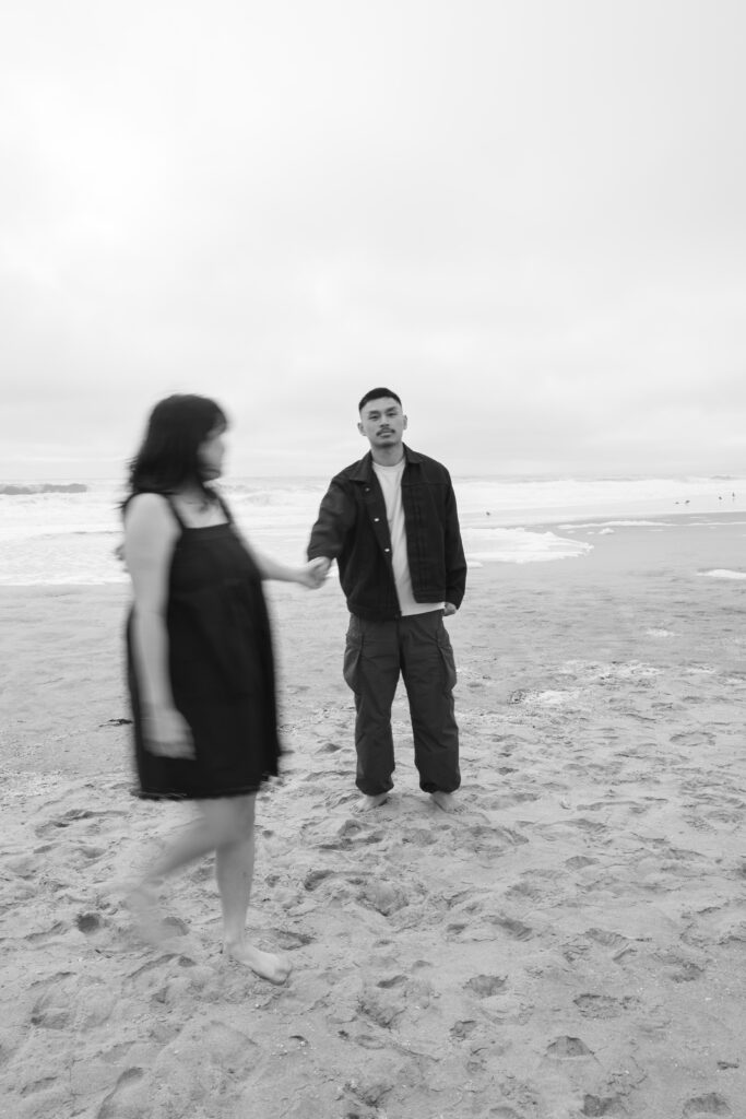 Black and white couple on Half Moon Bay beach with motion blur, Bay Area photographer Rose Freedman