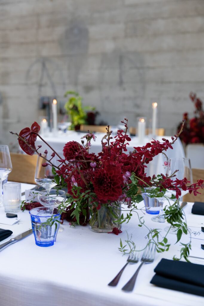 Wedding reception table with burgundy floral centerpiece and candles at Foreign Cinema San Francisco, Rose Freedman Photography