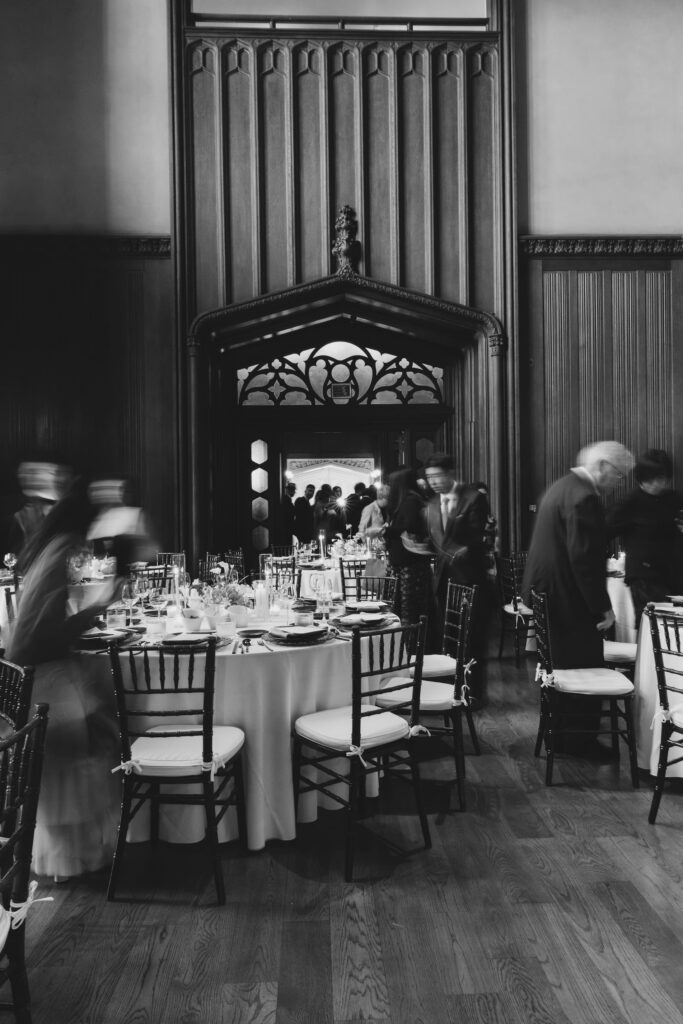 Wedding guests entering candlelit reception hall through Gothic arch at Kohl Mansion Burlingame, Bay Area wedding photographer Rose Freedman