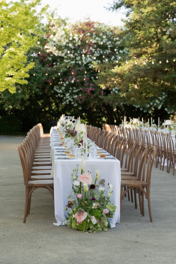 Outdoor reception long feasting table setup with garden floral centerpiece and taper candles at Park Winters, Park Winters wedding photographer Rose Freedman