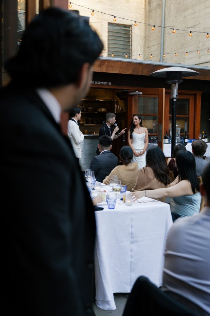 Wedding reception at Foreign Cinema San Francisco courtyard with magician performance, San Francisco wedding photographer Rose Freedman