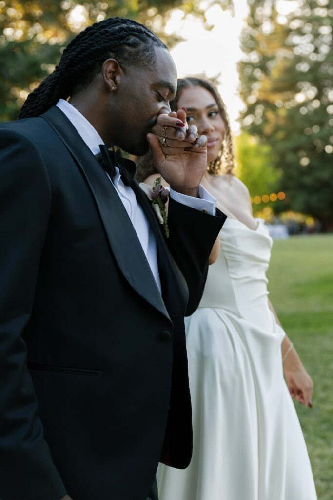 Groom kissing bride's hand at golden hour at Park Winters wedding, Park Winters wedding photographer Rose Freedman
