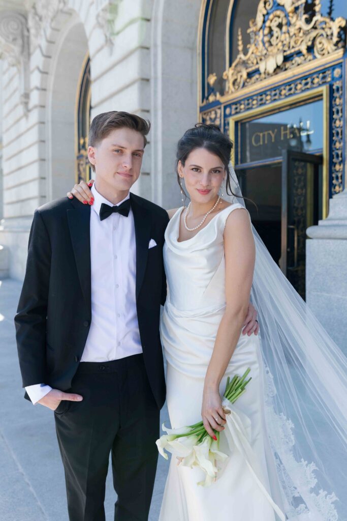 Bride and groom portrait outside SF City Hall entrance, San Francisco wedding photographer Rose Freedman