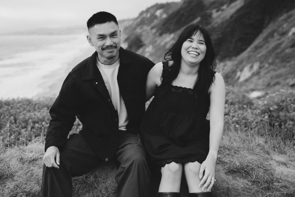 Couple laughing on Half Moon Bay coastal bluff, black and white film couples photography, Rose Freedman Photography