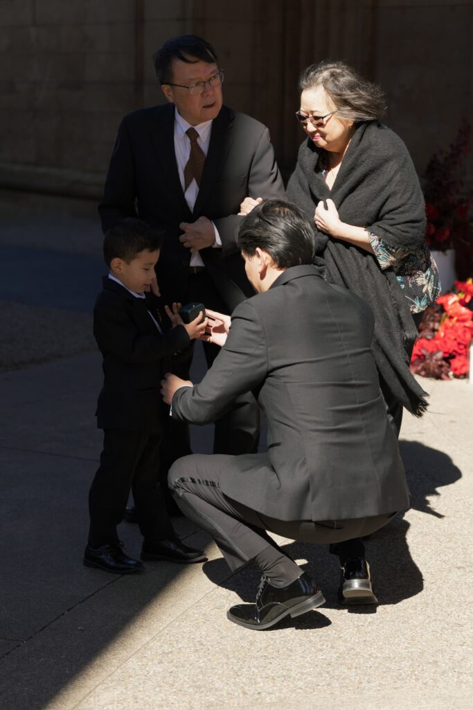 Groom greeting young family member before Palace of Fine Arts wedding ceremony, San Francisco wedding photographer Rose Freedman