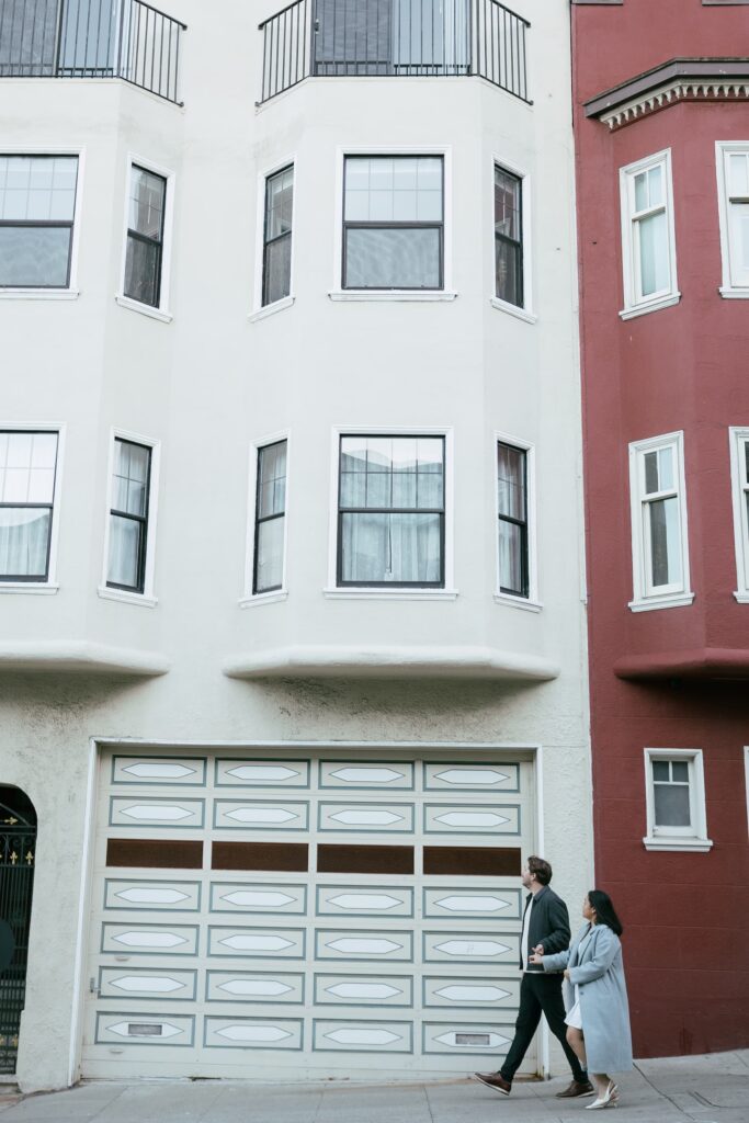 Couple walking past colorful San Francisco Victorian buildings, city engagement session Rose Freedman Photography