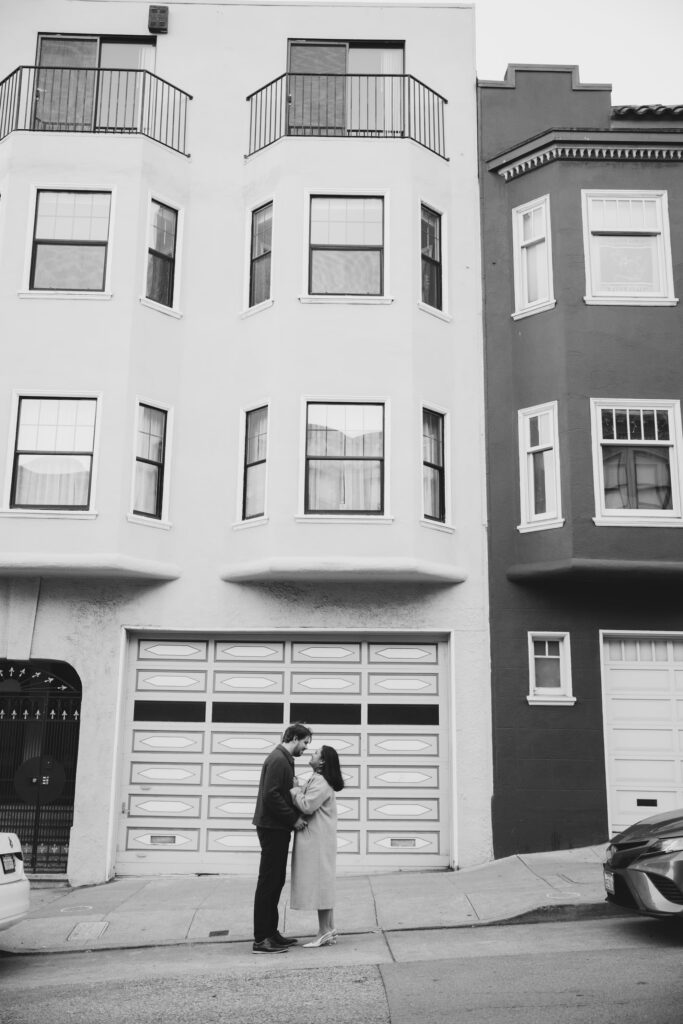 Couple kissing in front of San Francisco Victorian building, urban engagement photographer Rose Freedman