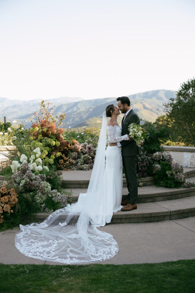 Bride and groom at floral altar with Santa Lucia Mountain views at Holman Ranch, Carmel Valley wedding photographer Rose Freedman